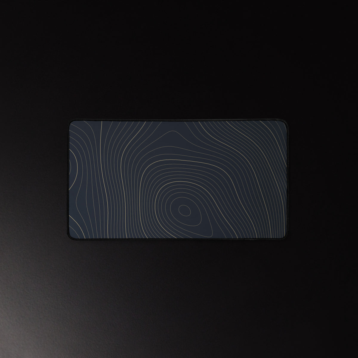 Midnight Contour desk mat, brass contour lines on navy, 12 by 22 inches