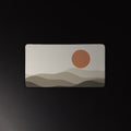 Paper Hills desk mat, terracotta sun over layered hills, 12 by 22 inches