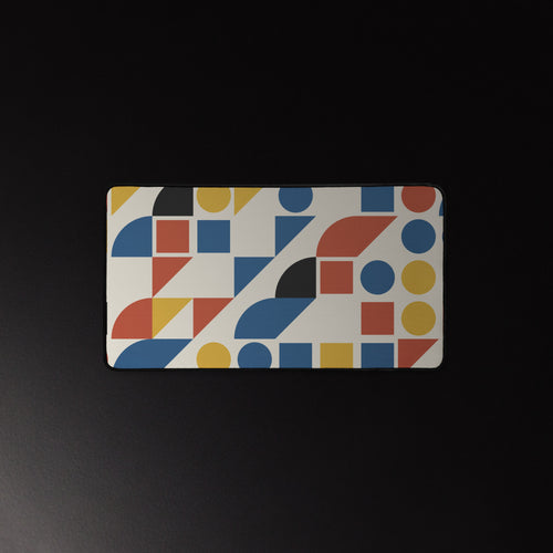 Bauhaus Grid desk mat, mustard, brick red and cobalt shapes on cream, 12 by 22 inches